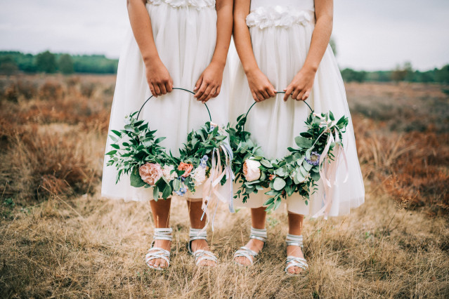 Veldbloemen aan een ring die bruidsmeisjes vasthouden