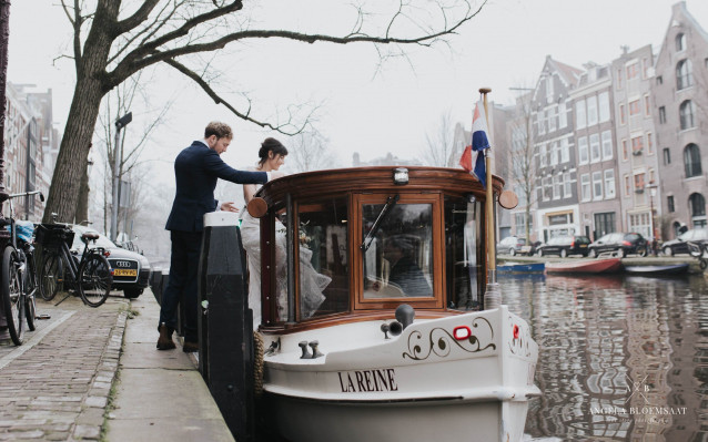 Bruidspaar stapt in het huwelijksbootje aan de Amsterdamse gracht