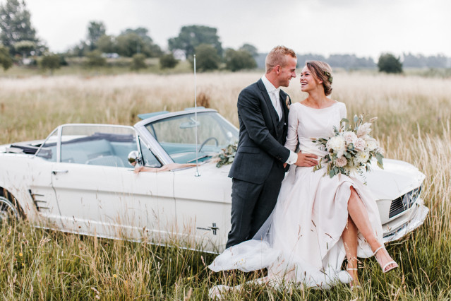 Brautpaar am Hochzeitsauto