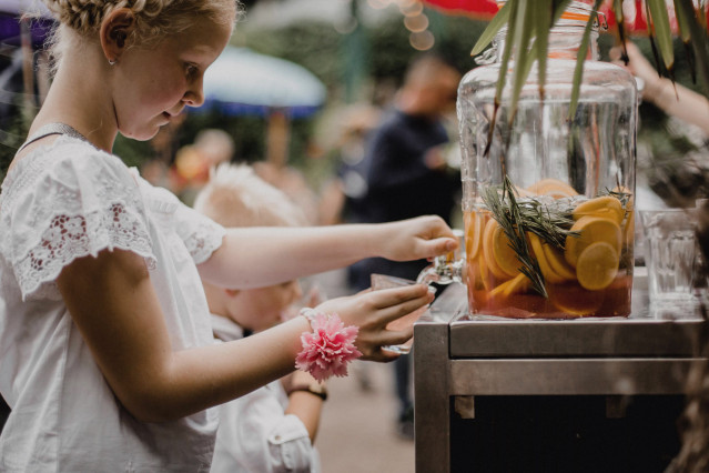 Kind op bruiloft tapt limonade uit een kan