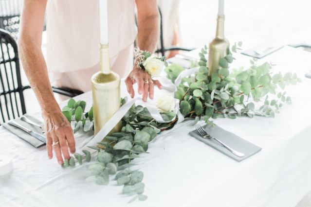 Brautmutter Aufgaben - Mutter der Braut kümmert sich um die Tischdeko auf der Hochzeit