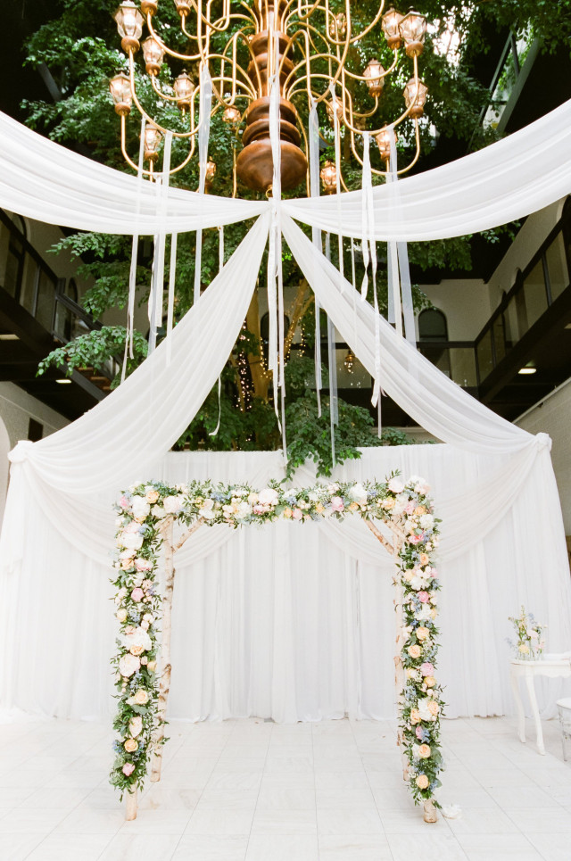 Weißer Backdrop mit Blumengestecken - Dekoverleih Hochzeit