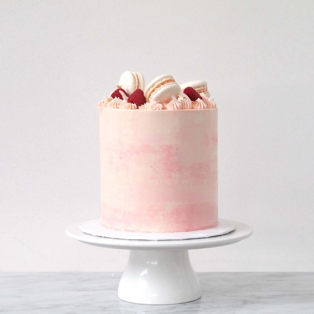 Kleine Hochzeitstorte in rosa mit Macarons als Topping